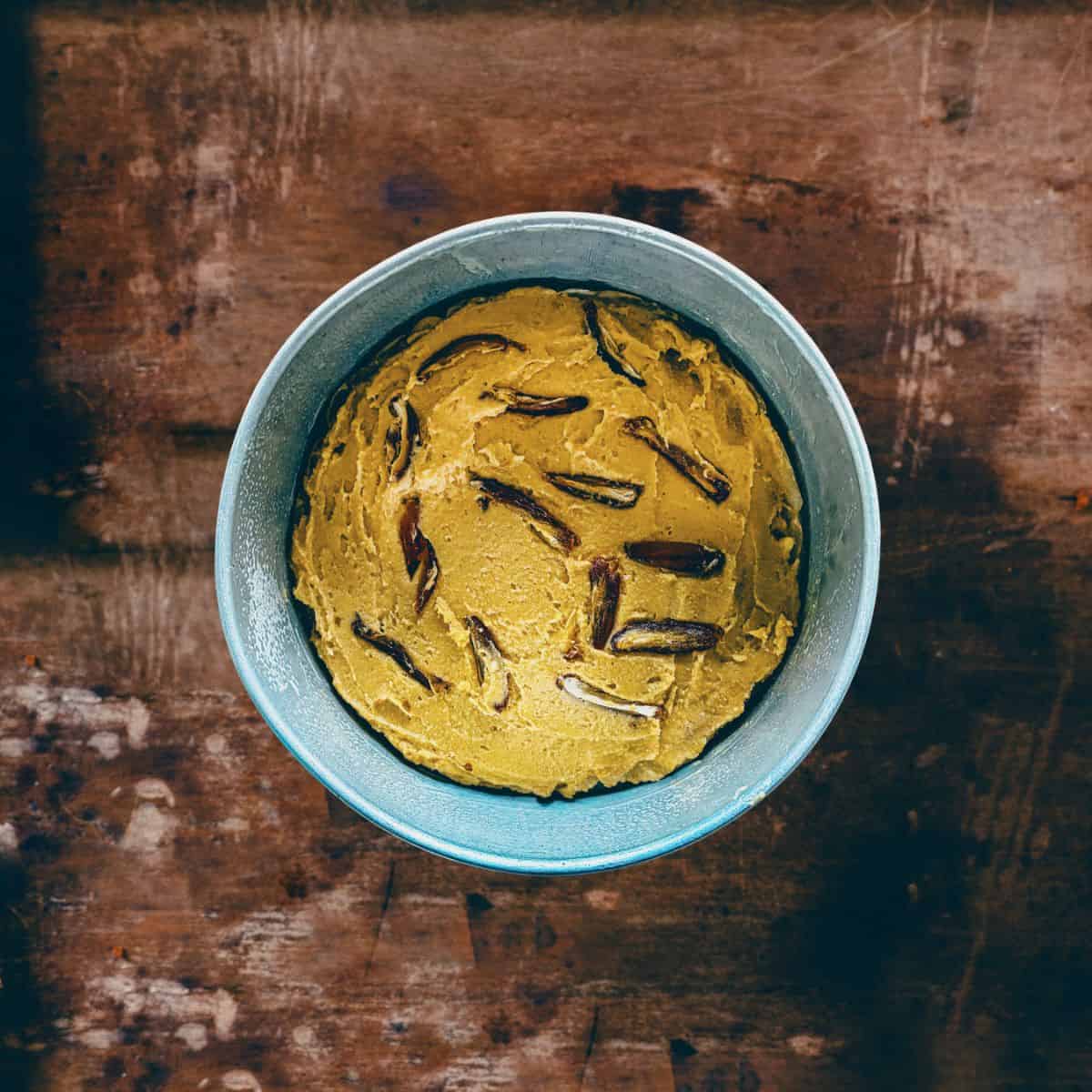 Cake batter with dried figs in tin before baking.