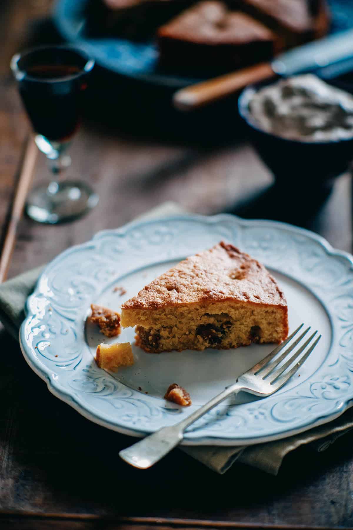 Slice of dried fig and almond cake on plate.